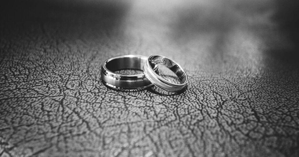 Two wedding rings on leather surface for a marriage that didn't work during midlife transformation. 